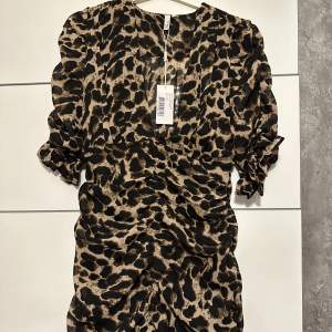 Säljer en fin leopard klänning som jag inte har tagit på mig. Den är helt ny och prislappen står fortfarande på. Är i storlek 36 och är medel lång.