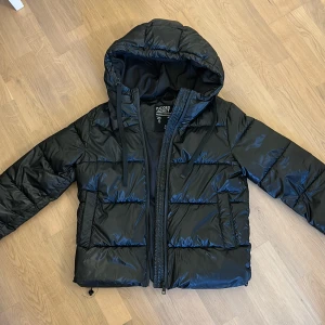 Glansig vinter jacka  - Jätte snygg glansig vinter jacka i ett varmt material. Den är knappt använd så den är som nyskick. Passar till allt. Passar perfekt på mig som brukar ha xs eller ibland s i jackor 