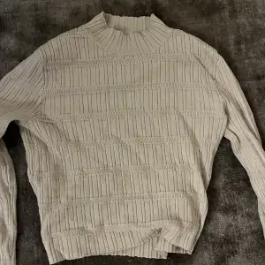 En beige tröja med mönster i storlek S