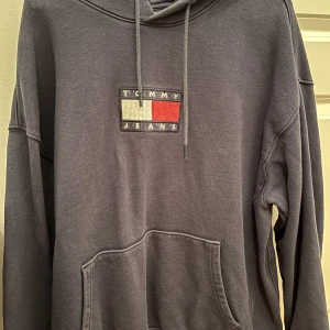 Tommy Hilfiger Hoodie - Tommy Jeans hoodie som jag knappt använder, 8/10 skick, perfekt till vintern, passar både M och L, nypris var ungefär 900kr men kom gärna med andra förslag :)