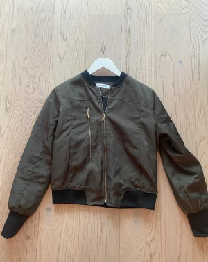 Kort jacka army - Bomber jacka från Cocouture i army färg, stl small Tunnare material så du även kan ha den inne! Använd ngn gång bara.