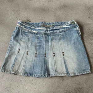 Kort Jeanskjol med nitar - Skitsnygg Y2K jeanskjol med nitar. Storlek S/XS kan även skicka exakta mått. Köpt från en vintage butik i Paris