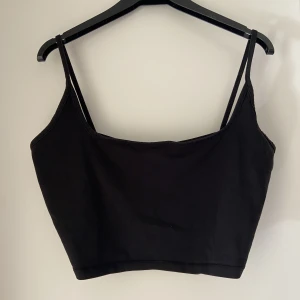 Kort linne  - Svart kort linne med fyrkantig halsringning och smala axelband i storlek 46/L. Men M går också bra. Använd några få gånger.