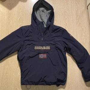Napapijri jacka (M) - Köpte jackan inför vintern förra året och har använt den ett antal gånger. Det är den jacka som har lite tjockare material så den passar bättre till vintern än hösten. Har du frågor är det bara att ställa