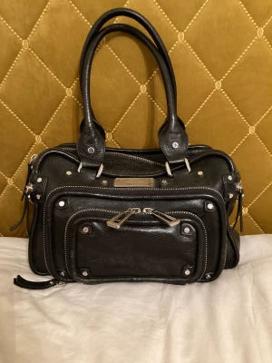 Väska, Karen Millen  - Äkta skinnväska från Karen Millen. Massa små fack, detaljer i silver. 32 cm bred, 15,5 djup, 20cm höjd. Köparen står för frakt 