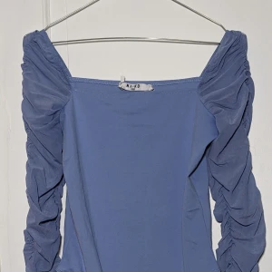 Ljuslila partytop - Så snygg festbody med mesh ärmar! Några sömmar släppte framtill när jag provade. Annars är den i nyskick!