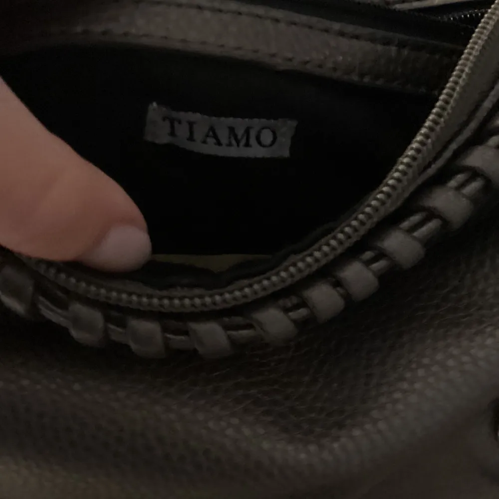 Säljer denna Tiamo väska då den inte används så mycket💘 använd sparsamt och har lite effekter på baksidan men det syns inte när man har på sig den❤️köpt på hemsidan för ett år sedan och då kostade den 499 säljer nu för 270 + frakt❤️     ⚠️TRYCK EJ PÅ KÖP NU⚠️. Väskor.