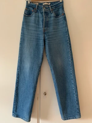 Levi’s Ribcage Jeans - Levi’s jeans i modellen ribcage, färgen är denimblå! Använt dessa endast ett fåtal gånger och nu är de dessvärre för små för mig. I väldigt bra skick. På mig som är 157 sitter dessa så att de lägger sig ”på” skorna, alltså lite längre.