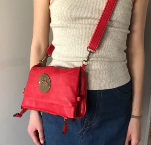 Röd axelremsväska - Säljer denna röda axelremsväska från Mulberry! Den är i mycket bra skick och från ett ganska dyrt märke, därmed liiite högre pris. Säljer på grund av aldrig använt! (Har för mycket väskor)