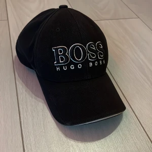 Hugo Boss Keps - Har använt den i 1 år. Äkta, lite rostad där bak. Funkar helt perfekt