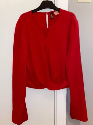 Röd blus från H&M - En röd tunn blus inköpt på H&M. Då den hade lite mycket uringning är den sydd några centimer uppåt där. Knappt använd. Storlek 36. Pris kan diskuteras