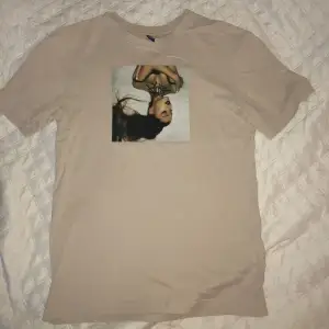 T-shirt i fint skick. Men XS i storleken, så lite lösare passform för tjejer. Tryck på framsida och baksida. Beige med lite rosa ton. Skriv om ni vill ha fler bilder. 