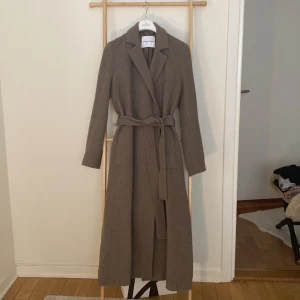Lång ullkappa samsoe samsoe nyskick - Superfin lång kappa från Samsö Samsö, modellen ”Astrid”.  Nypris 3995kr. Nyskick!  Xs, men stor i storleken, motsvarar small eller 36.  Färgen:Taupe  https://www.samsoe.com/se/woman/clothing/jackets-and-coats/coats/astrid-coat-11104/5711453044125.html