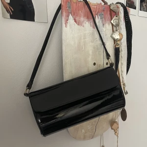 Handväska svart  - Svart handväska i lack! Den har ett litet fack inuti😍