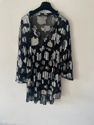 Zara klänning  - Zara klänning i silver o svart  Storlek L, men passar även storlek S då jag har det Skulle säga att passformen är M