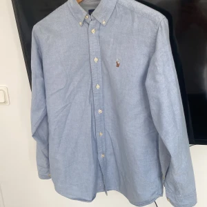 Ralph lauren skjorta - En fin Ralph lauren skjort som jag nu tyvärr växt hur.  De är en stilren och klassisk skjorta som passar till många tillfällen. De är bra skick på den. Storleken är för 14 år men skulle säga att de är en xs/s