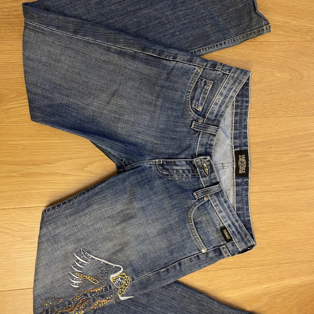 Jätte snygga lågmidjade, straight/ bootcut Versace jeans som har snygga detaljer( fickor, ängel vid benet) bra skick men en lapp där bak har suddads ut för det förut stog VC men det är inget man lägger märke till!. Jeans & Byxor.