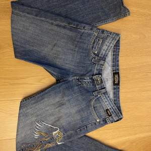 Jätte snygga lågmidjade, straight/ bootcut Versace jeans som har snygga detaljer( fickor, ängel vid benet) bra skick men en lapp där bak har suddads ut för det förut stog VC men det är inget man lägger märke till!