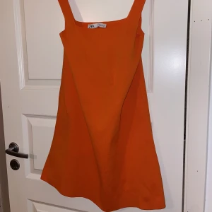 Orange square neckline miniklänning - Orange miniklänning från zara med en fyrkantig sömn. Super fin till sommaren när man är brun. Använd en gång för bild så inga skador eller fläckar. Pris kan diskuteras. 