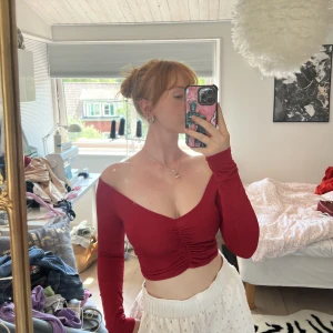 Snygg röd partytop - Snygg och figurpassande top i en blänkande körsbärsröd färg! Kan vad både on shoulder och off shoulder. Endast använd 1 gång och är i storlek 36, i ett stretchmaterial.