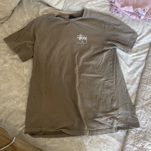 Tshirt från Stussy  - Tshirt från märket Stüssy. Köpt i Australien   Är en storlek 6. Passar xs, s och m men beror på hur oversize man vill ha den. 