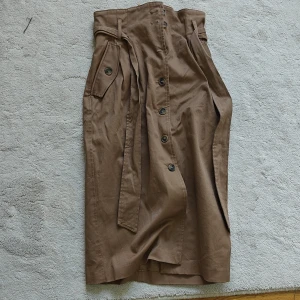 Snygg kjol - Jättefin brun kjol med både knappar och ett band runt midjan. 