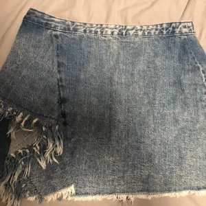 Jeanskjol  - Jag säljer en jeanskjol från zara med volanger på ena sidan. Den är knappt använd och den passar s-m.