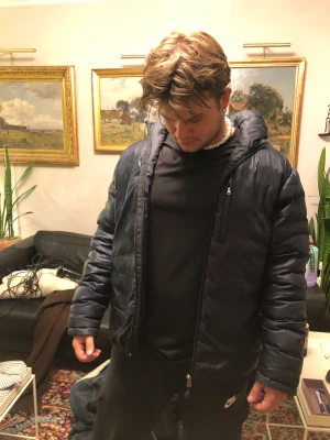 Pufferjacket - Snygg stilren pufferjacket som håller dig varm under de kallaste vinterdagarna, bra kvalite har en liten skada på ryggen i övrigt bra skick. Passar både man oh kvinna 