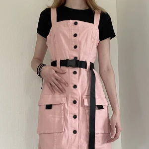 Jeans klänning - Rosa jeans klänning med svarta detaljer. I storlek 38, är något liten i storleken. Aldrig använd så klänningen är som ny.