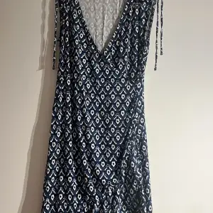Marinblå mönstrad klänning i viskos från Flash i strl S   V-ringad och volang nertill