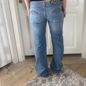 Lågmidjade jeans - Världens snyggaste lågmidjade jeans i perfekt ljus tvätt och utsvängd modell! Helt nytt skick med lappar kvar💕 Storleken passar en M med långa ben. Skriv vid funderingar och kolla in mina andra annonser💫