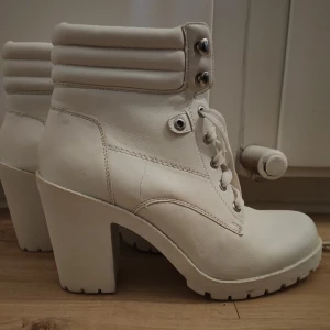 Skor stl 40 - Vita kängor med klack. Oanvända men har stått länge i ett skåp med andra skor så kommer tvättas/fläckbehandlas innan dom skickas🥰 Storlek 40