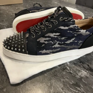 Louboutins - Modell: LOUIS JUNIOR STUDDED CAMOUFLAGE-JACQUARD TRAINERS IN NAVY.  Slutsåld modell från Louboutin. Cond 8/10 (inget OG kvar)  storlek 43 Självklart äkta! Önskas mer info, kom pm🙏🏻