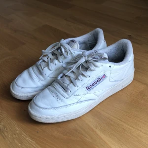 Reebok Club C - Beige Club C’s med vinröda detaljer. Väldigt bra skick förutom lite ludd på insidan av hälen. 