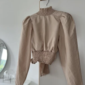 Blus med smock - Beige blus med smock och öppen rygg från Gina strl S 🤍 Fint skick!  Kan skickas, köparen står för frakten 🥰