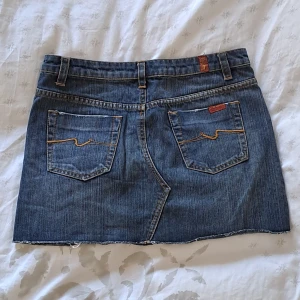 7 for all mankind kjol - Säljer denna jättefina 7 for all mankind jeanskjol som är i princip nyskick🫶💎Kjolen har enkelt men fint broderi på bakfickorna💙 Vet inte riktigt storleken, men har följande mått: Midja-38/39 cm ☆ Längd-34/35 cm  Fråga vid fundering och använd köp köp nu😊❤️