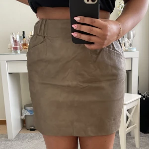 Skinnkjol - Fin beige/brun kjol, med reså band som formar midjan. Köpt från Zara använd endast två gånger. Storlek Xs passar även som S