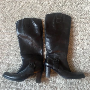 Boots  - Svarta boots i storlek 40. Med snygga spännen på sidan av skorna. 