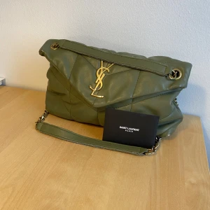 YSL väska - Väskan har lite slitningar och även lite slitage på själva märket. Köpt på Plick för ca ett år sedan då jag fick betala ett par tusen. Väskan hade  mått bra av en tvätt. 