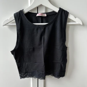 Svart linne med spets - Svart linne från pink woman. Den är croppad och har spets nertill. Bra skick!