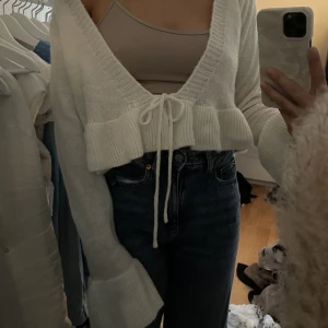 Stickad kofta - En vit stickad kofta med volang ärmar och knytning ❄️