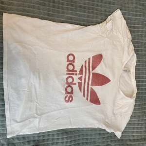 Adidas tröja  - Använd väldigt få gånger. Köpt från london. Vit tröja med rosa glittrig text, säljer då den är för liten för mig. Skulle säga att det mer är storlek s eller xs 