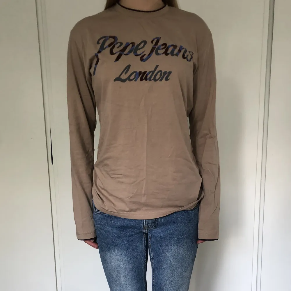 Beige långärmad top ifrån pepe jeans med bruna detaljer vid krage och ärmarna. Står strl xl på tröjan men passar S/M. Fint skick utan några skador💗. Toppar.