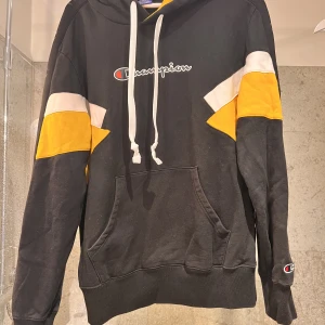 Champion hoodie - Svart champion hoodie med gula och vita kontraster. Knappt använd köptes för 900kr. Pris kan diskuteras vid snabb affär 