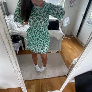 Säljer denna gröna klänning från Pernilla Whalgrens kollektion, klänningen är vit med gröna blommor och har resår i midjan. Säljer pga att den knappt kommer till användning🦚