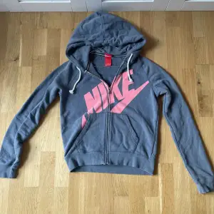 Nike hoodie i grå/blå med rosa text. 