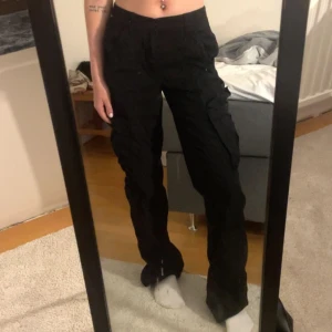 Cargopants - Svarta lågmidjade cargopants💗 helt oanvända. Storlek 32, jag är 168 och har xs/s i byxor. (smutsig spegel lol)