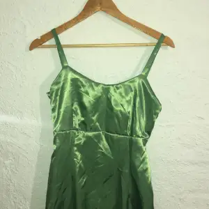 Grön silkes klänning, sydd av mig alltså inte köpt. Fint skick med slit på sidan. Är cirka 164 och den går ner till fötterna. Fina sömmar och stryks och tvättas innan postning. Använd en gång.