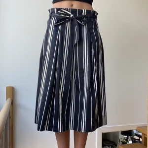 Kjol - Säljer denna svart och vit randiga kjolen från H&M. Kjolen är i mycket fint skick!💕