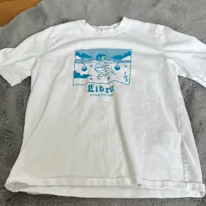 Oanvänd t-shirt från HM med vågens stjärntecken. Strl XS. Köptes för några månader sedan.